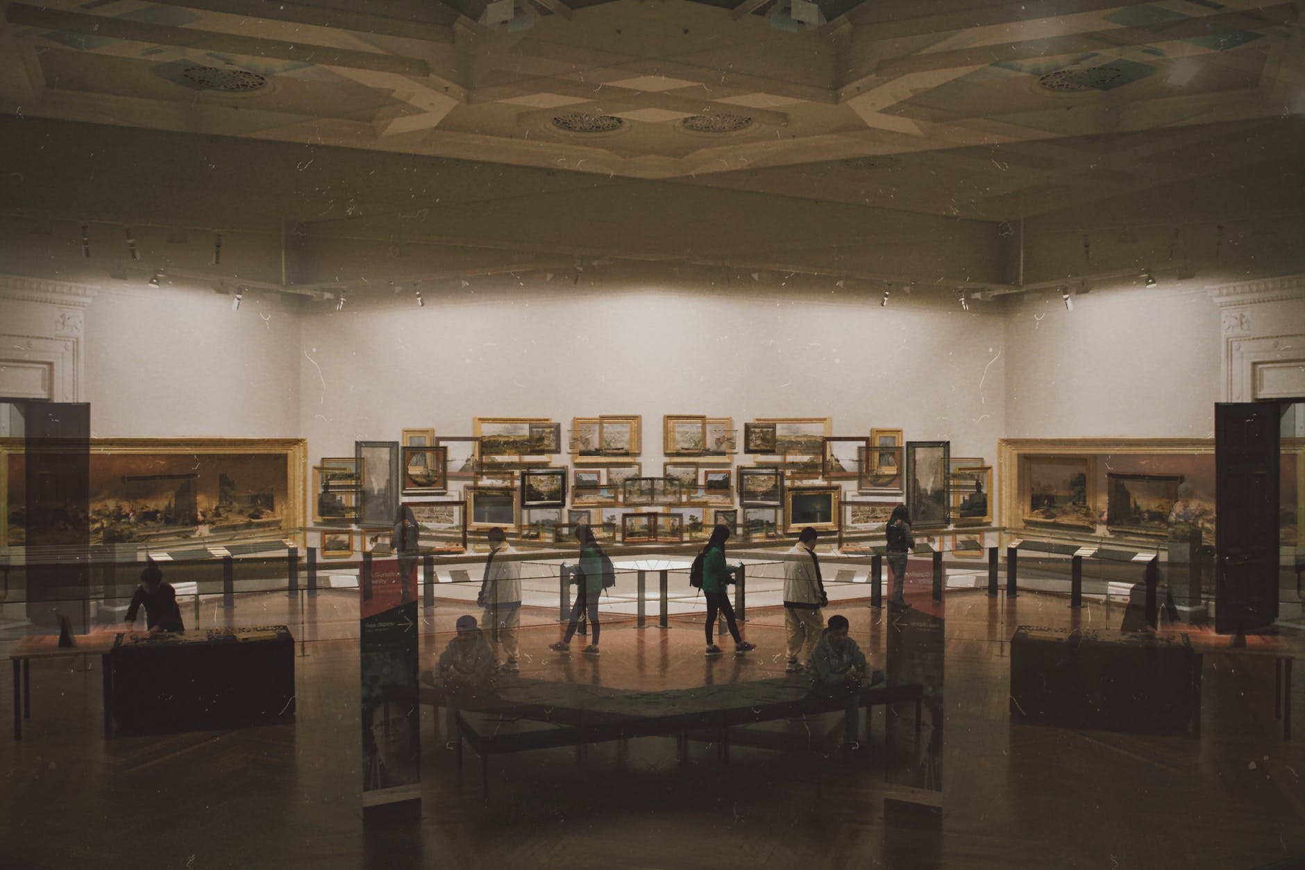 博物館展廳內牆上掛滿古典油畫,遊客在展示櫃間靜靜參觀