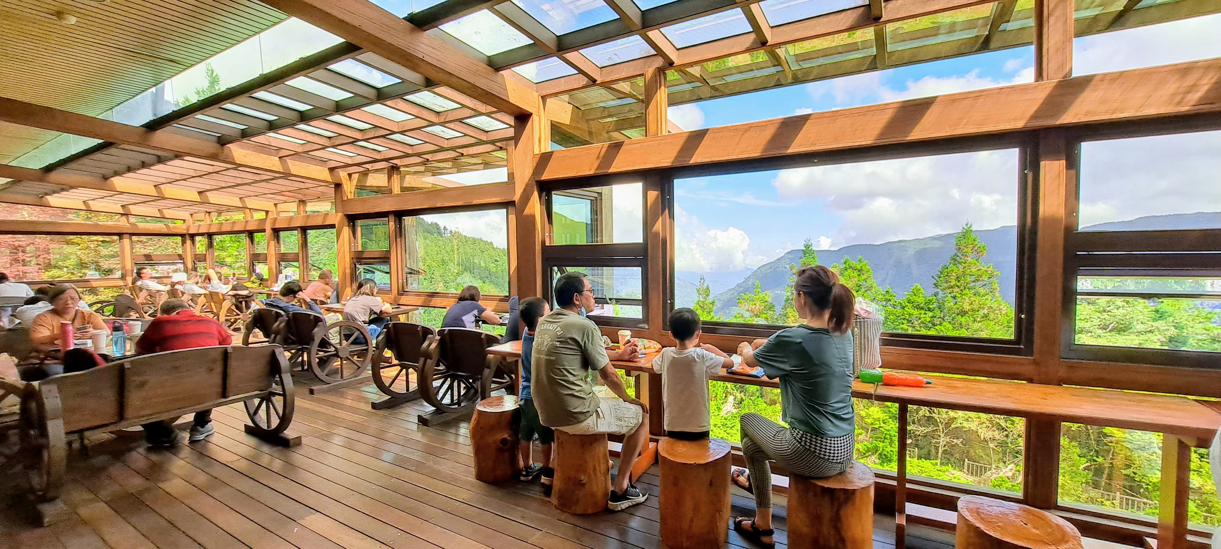 雲海咖啡館室內座位區，遊客透過大片落地窗欣賞山景