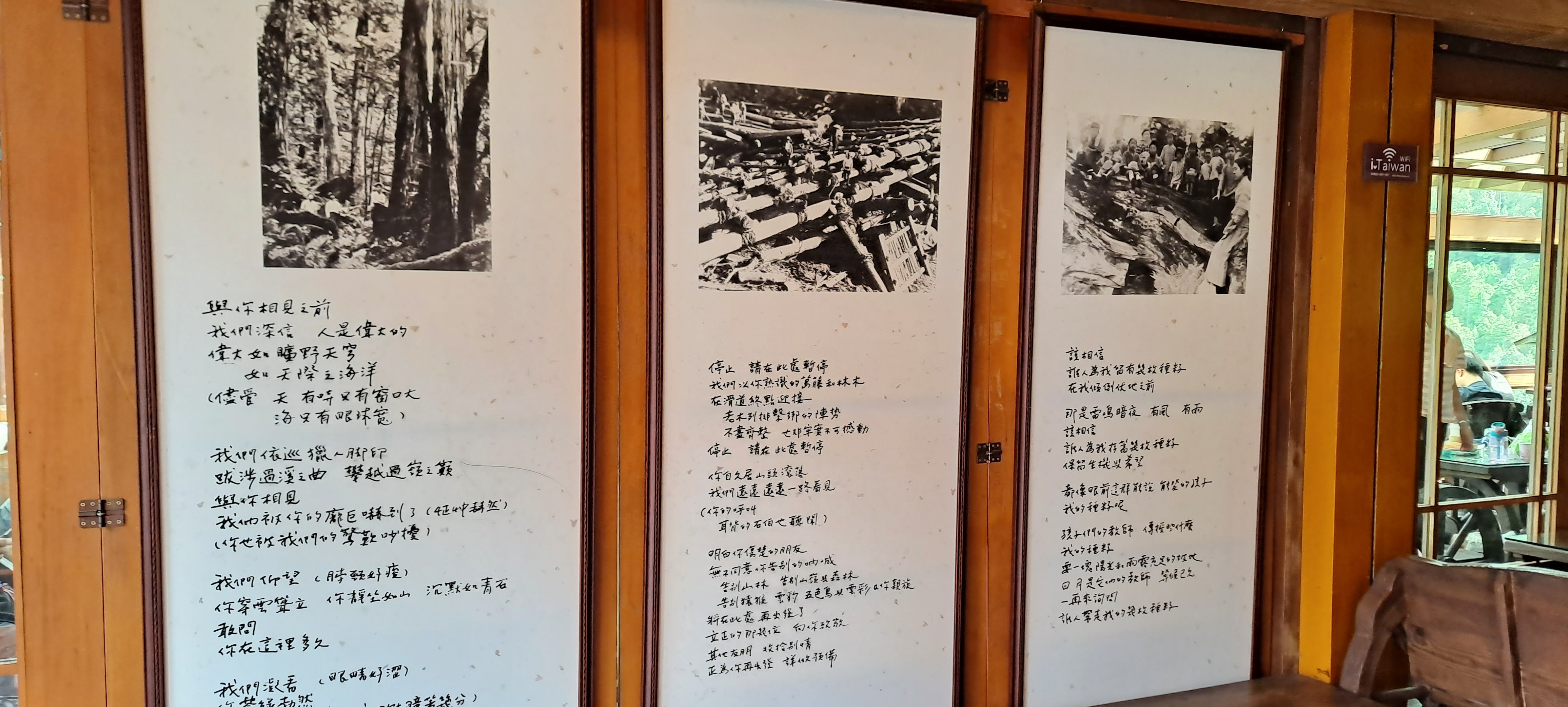 咖啡館牆面展示黑白老照片與手寫詩句，記錄太平山伐木歷史