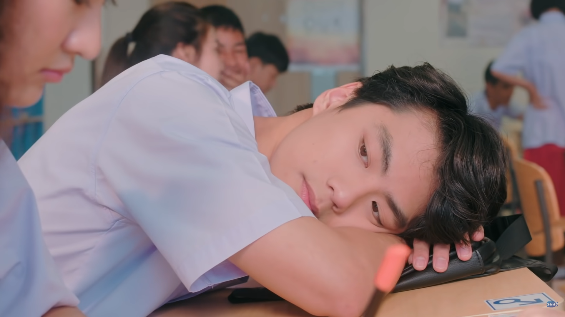 泰劇《The Shipper》劇照:男學生趴睡在教室書桌上,望向鏡頭若有所思
